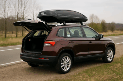 Porodica ubacuje torbe u otvoreni krovni kofer na automobilu parkiranom pored puta